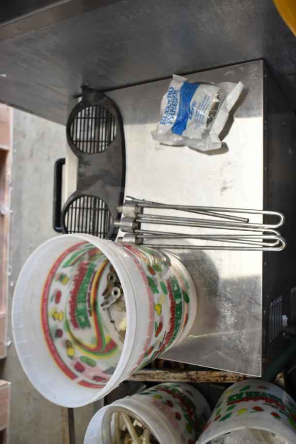 92 ice cream machine parts, including handles, metal rods, and plastic bucket with colorful fruit pattern.