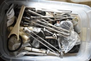 Container filled with 54 various Taylor ice cream machine parts, including metal rods and plastic components, some in bags.