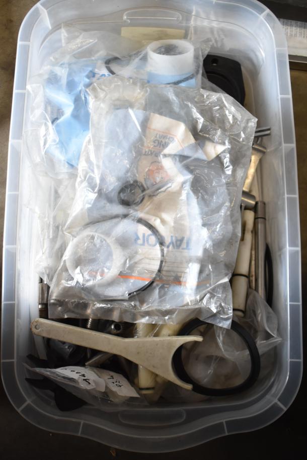 Plastic bin with 54 Taylor ice cream machine parts, including rings and tools, in clear bags, various conditions.