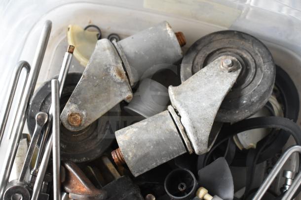 Box of 54 assorted items includes Taylor ice cream machine parts, metal casters, rods, and wheels. Used condition shown.