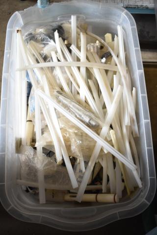 Plastic bin containing 63 various ice cream machine parts, including tubes and connectors. Appears used, suitable for Taylor machines.