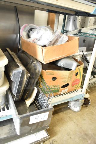 Box of assorted ice cream and frozen beverage machine parts, includes trays and containers, condition varies.