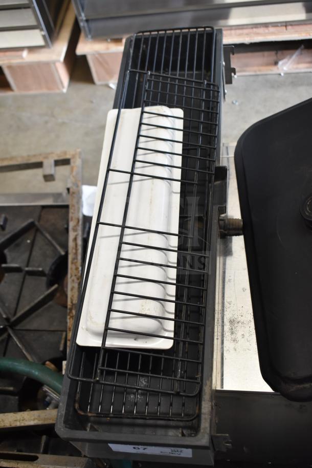 Assorted ice cream and frozen beverage machine parts. Includes metal and plastic components, arranged on industrial racks.