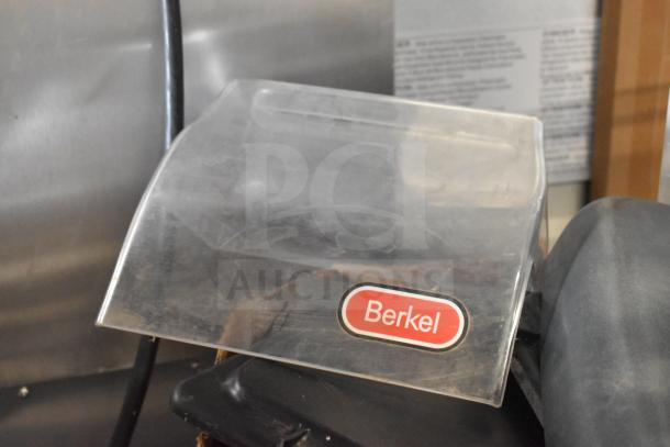 Clear plastic cover with Berkel logo on ice cream machine part, showing signs of wear. Part of 40-item auction lot.