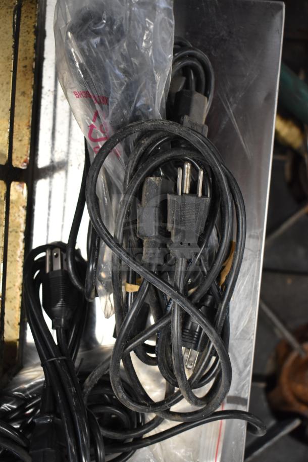 Assorted wires and a drip tray in used condition, bundled together. Includes various power cords.