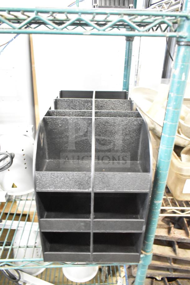 Black poly lid dispenser with multiple compartments, used condition, ideal for organizing lids in a commercial setting.