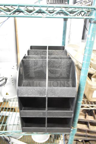 Black poly lid dispenser with multiple compartments, used condition, ideal for organizing lids in a commercial setting.