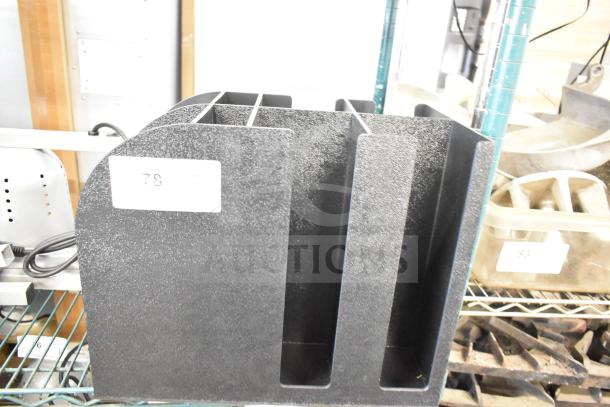 Black poly lid dispenser with four vertical slots. Features textured finish, label reads "78." Good condition.