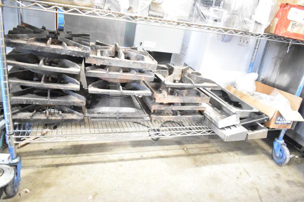 Collection of 29 items including range grates and Turbochef kick plates on a metal shelf, used condition.