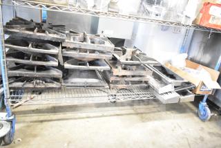 Collection of 29 items including range grates and Turbochef kick plates on a metal shelf, used condition.