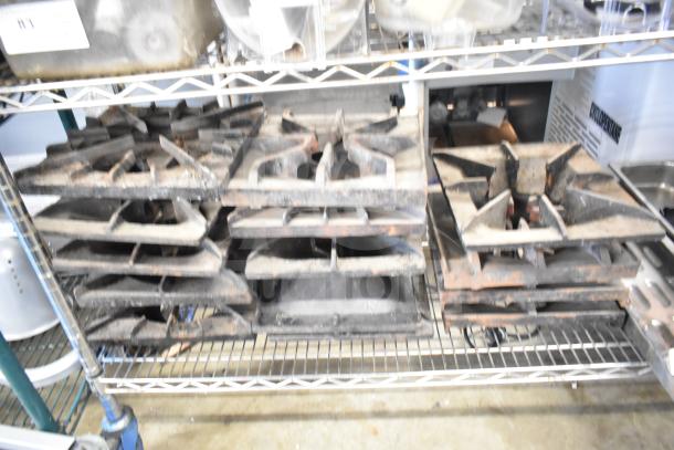 Metal range grates and Turbochef kick plates on a shelf, showing signs of wear. 29 items included.