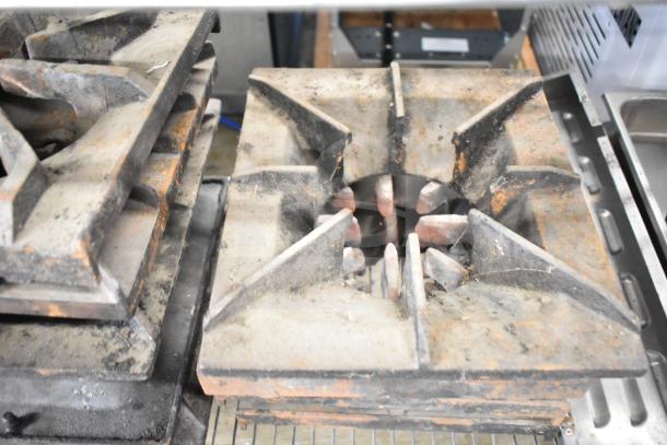 Stack of used range grates with visible rust, part of a lot including Turbochef kick plates. Auction: 29 items in total.
