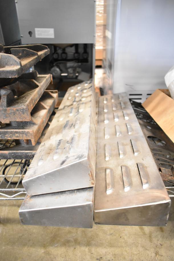 Assorted range grates and Turbochef kick plates, 29 pieces. Visible wear and rust. Auction lot multiplier applies.