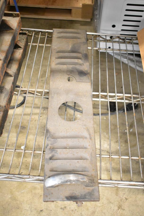Metal oven component with vented slots and circular opening, showing signs of rust, on a wire shelf. Part of 29-item auction lot.
