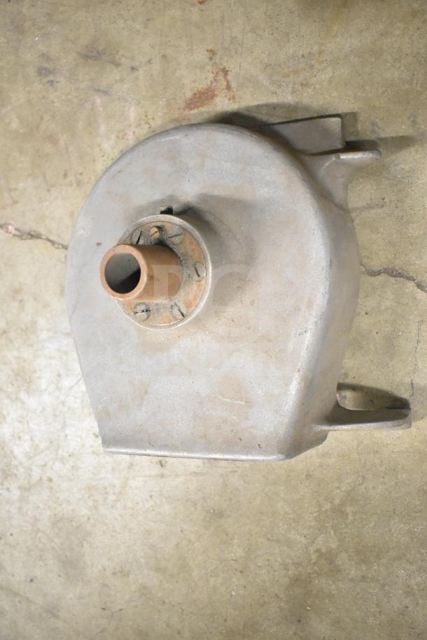 Metal grinder component featuring a circular design with a central tube. Appears used, surface scuffs visible.