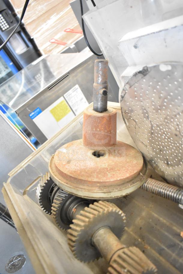Assorted kitchen equipment including gears and rusted metal components for meat grinder and beverage machine.