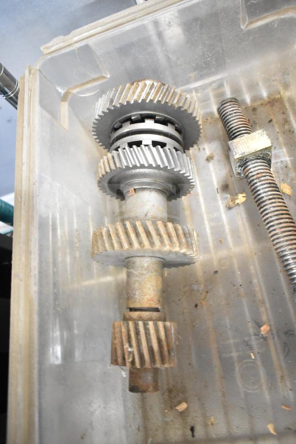 Metal gears and threaded rods in a clear bin, part of a lot including beverage machine hoppers, meat grinder tray, and more.