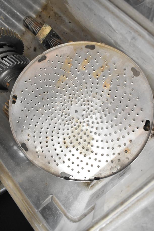 Assorted industrial equipment including beverage machine hoppers, a meat grinder tray, and a pelican grating blade; used condition.