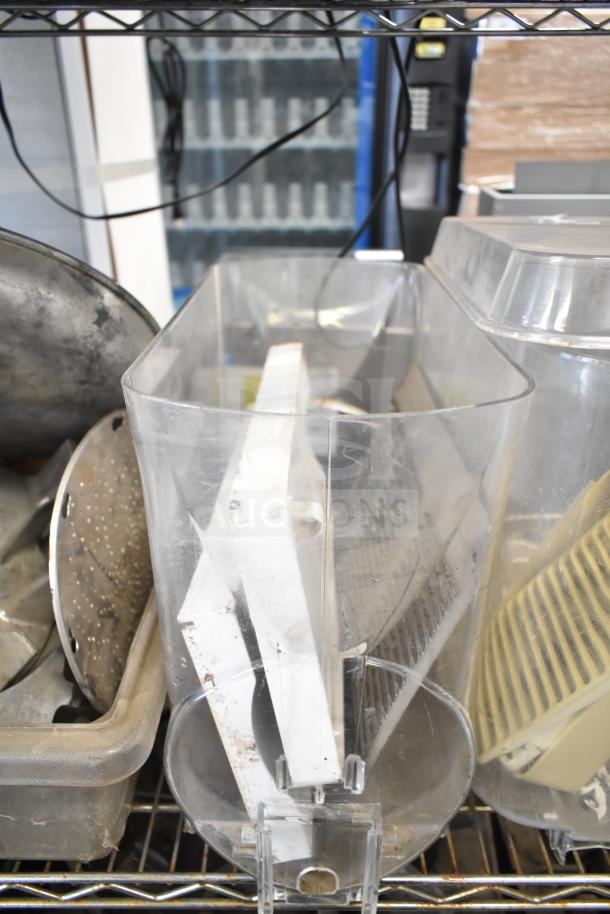 Assorted kitchen equipment including beverage machine hoppers, meat grinder tray, and pelican grating blade in used condition.