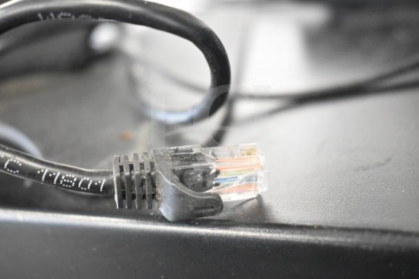 Close-up of a POS system cable with visible wiring and imprinted code "41801," part of a system including cash drawers, printer, and monitor.