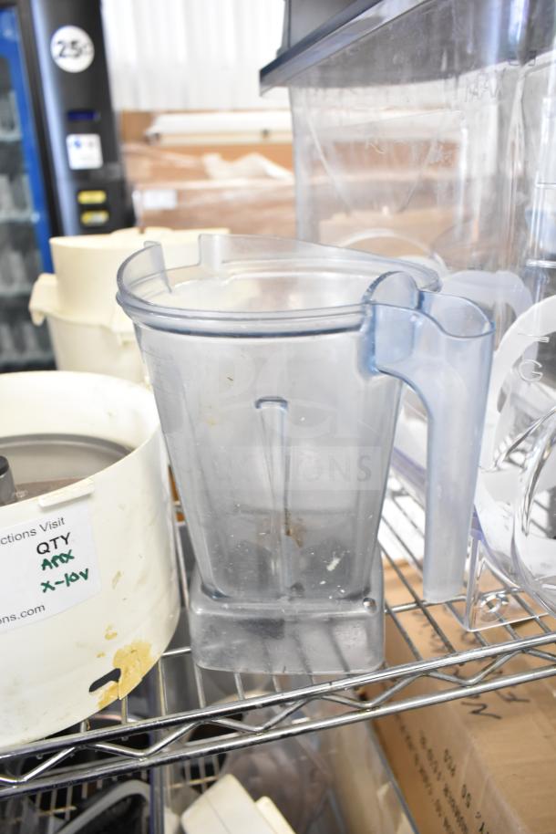 Assorted kitchen items including a slushie machine hopper, slicing blade, and blender pitcher, on a metal rack. Marked "QTY".