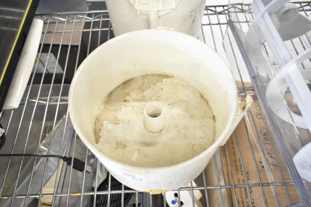 Lot of 10 various items including slushie machine hoppers, slicing blade, blender pitcher on metal shelf. Used condition.