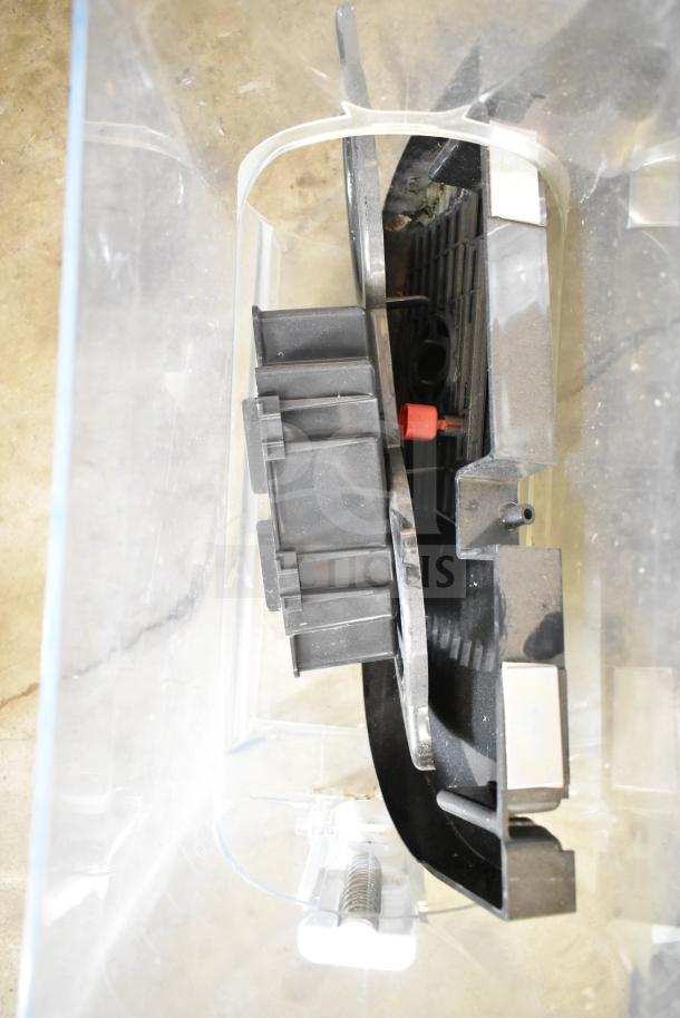 Clear plastic hopper with black and metallic components for a slushie machine, in used condition.