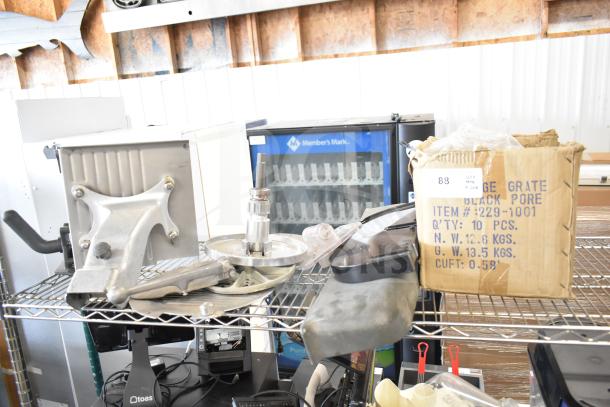 20 various kitchen equipment items including a meat slicer arm, pelican head blades, and food processor blades, on shelving.