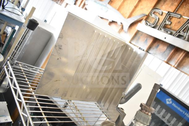 Stainless steel meat slicer arm on metal shelf, includes pelican head blades and food processor blades. Auction lot, 20 items.