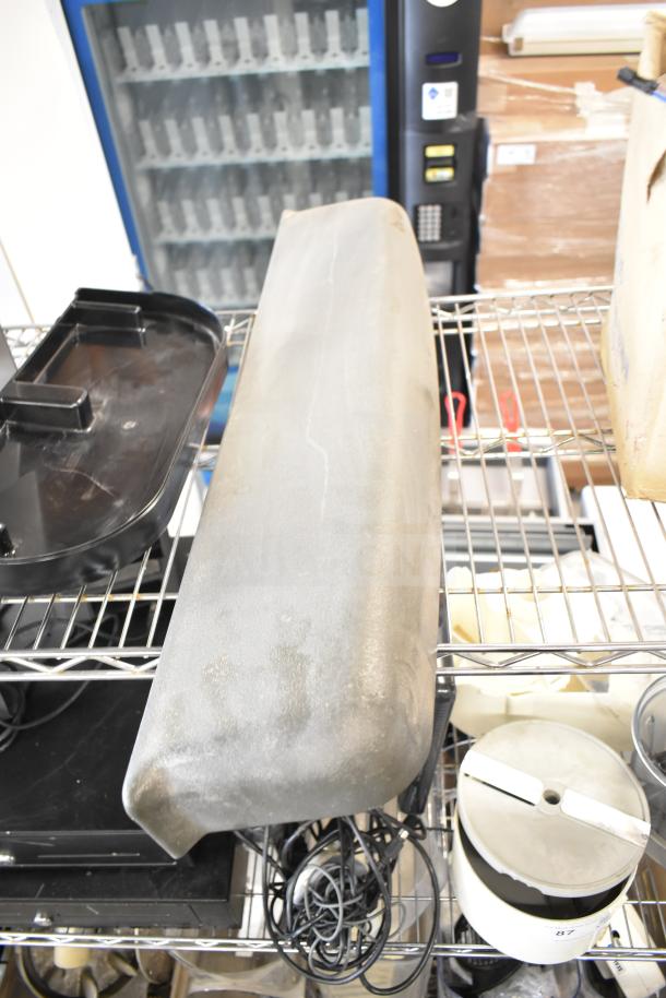 Various kitchen appliances and accessories including a meat slicer arm and pelican head blades on a metal shelf, used condition.