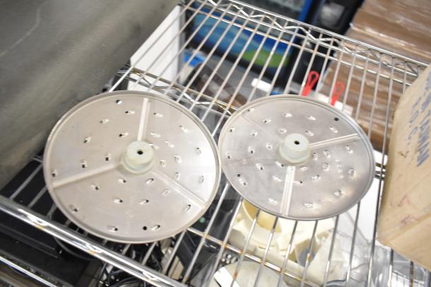 Two circular metal food processor blades on wire shelving, showing perforations. Part of a 20-item lot auction.
