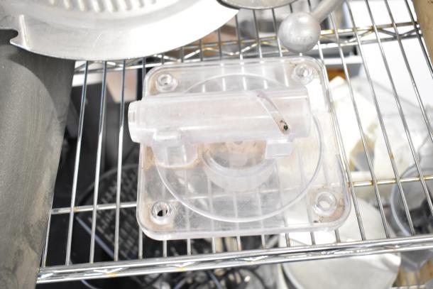 Assorted commercial kitchen parts including a meat slicer arm, pelican head blades, and food processor blades. Used condition.