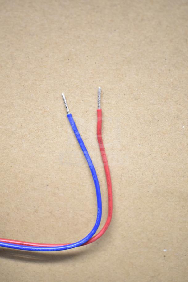 Red and blue electrical wires with exposed ends, labeled with specifications, against a plain background.
