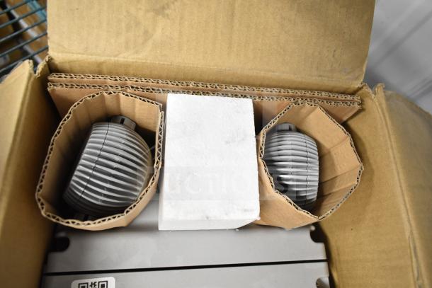 Brand new DualLite EVODW double remote head light in box, featuring protective packaging, ideal for emergency lighting setups.