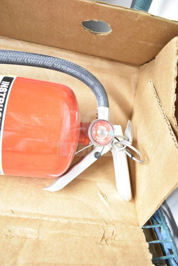 Brand new Sentry fire extinguisher with gauge and hose, in original packaging.