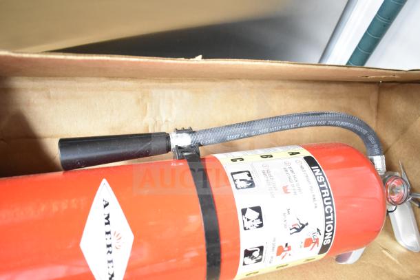 Brand new Sentry fire extinguisher in box, red with black hose. Amerex label visible, includes instructions.
