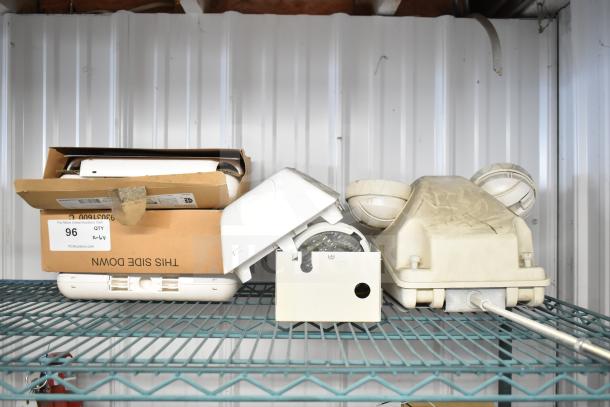 6 various electrical items including an emergency light on a metal shelf. Some items are boxed; others show signs of wear.