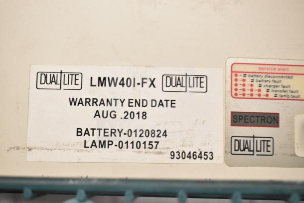 Dual-Lite emergency light label showing model LMW40I-FX and warranty end date August 2018. Includes service alerts.