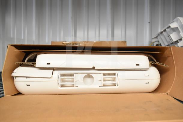 Cardboard box containing a white emergency light fixture, part of a 6-item auction lot. Light appears in new condition.