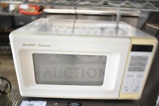 Sharp Carousel R-3A47 countertop microwave oven, beige, with control panel and viewing window. Includes plate, 120V, used condition.