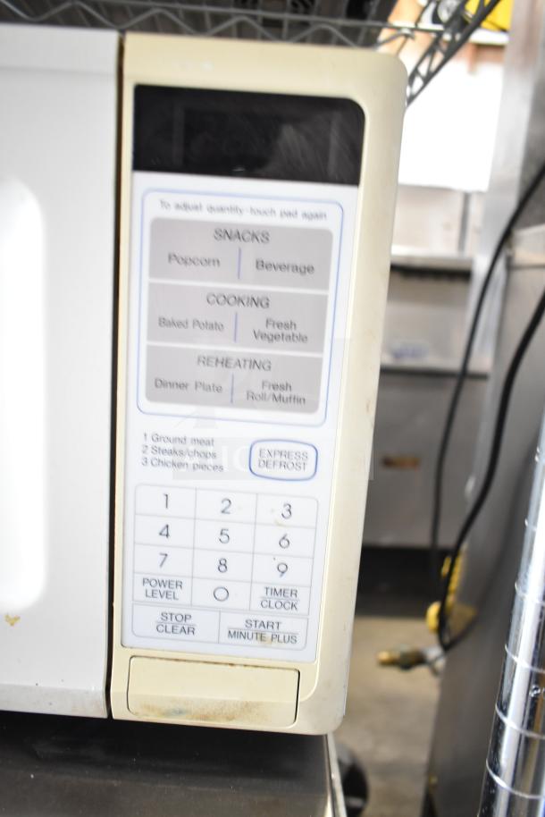 Sharp Carousel R-3A47 Microwave Oven, countertop model, keypad controls, includes plate, runs on 120 Volts, 1 Phase. Condition shows wear.