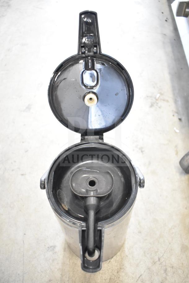 Three black air pots with open lids, showing interior spouts. Used condition, ideal for beverage dispensing.