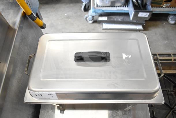 Stainless steel countertop chafer with black handle, showing visible wear. Auction tag number 112 displayed.