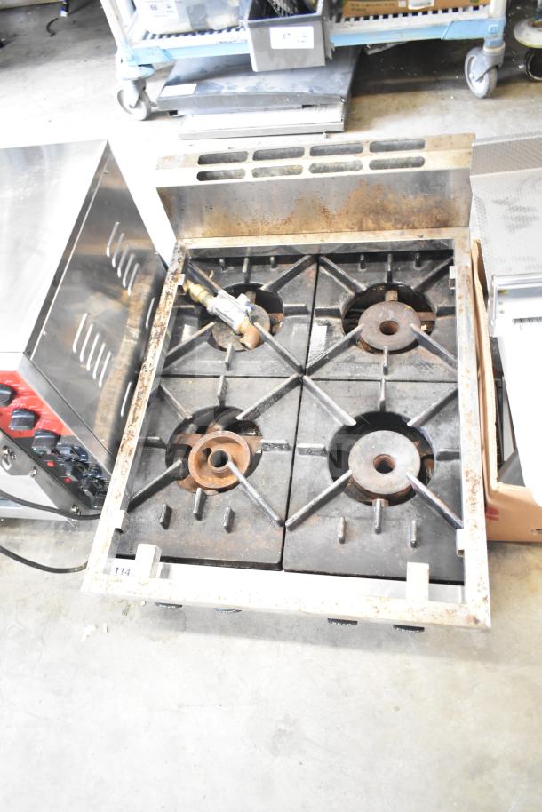 Commercial countertop gas-powered 4 burner range, used condition, visible wear, sturdy cast iron grates, auction item.