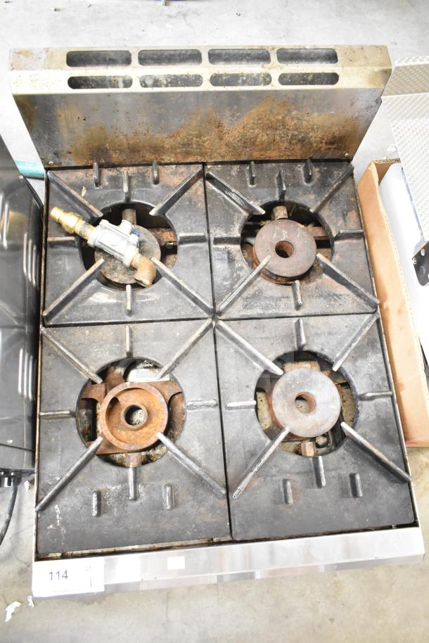 Commercial countertop gas-powered 4 burner range, used condition, with visible wear and rust on burners.
