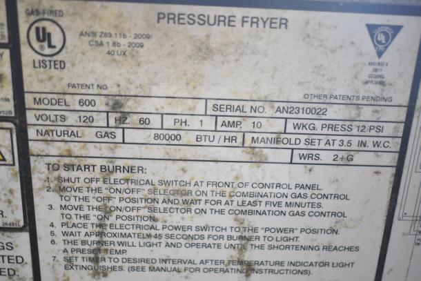 2022 Henny Penny 600 Pressure Fryer label, 80,000 BTU, natural gas, model 600, serial AN2310022, UL listed, operational instructions visible.