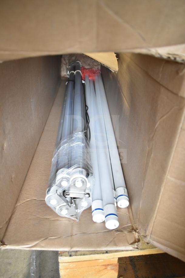 Box containing Philips tube lights and PT44070 2x4 LED light panel, showcasing six items in packaging, suitable for auction.
