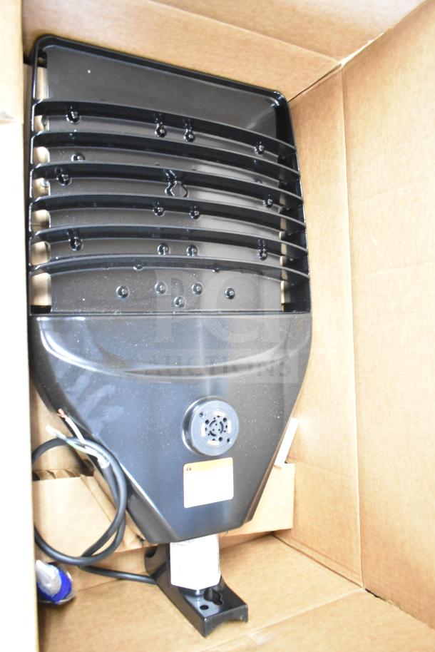 Black GE K5SM flood light, new in box, with wiring visible. Part of 16-item lot.