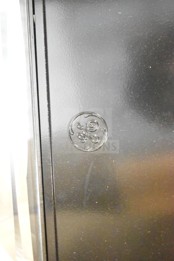 Alt text: "GE K5SM flood light, black casing with embossed GE logo, part of 16-item auction lot."