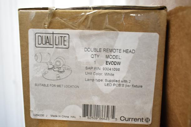 Close-up of DualLite EVODW Double Remote Head box. Label indicates model, SAP P/N: 93041098, color: white, suitable for wet locations.